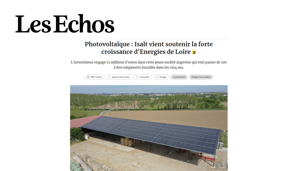 Panneaux solaires photovoltaïques sur un toit, devant des champs et des arbres.