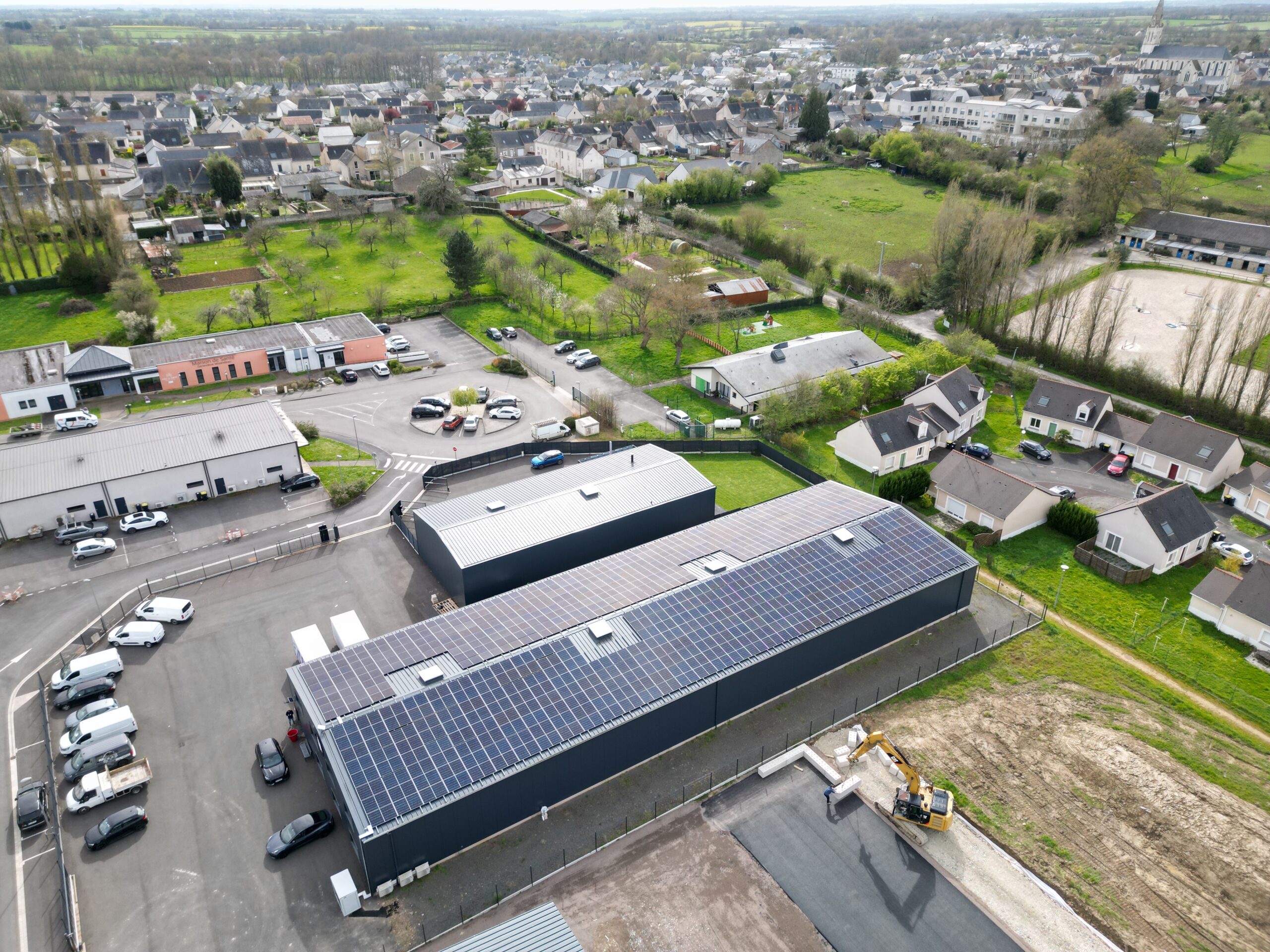 Vue aérienne d'un bâtiment industriel avec panneaux solaires, CM Services