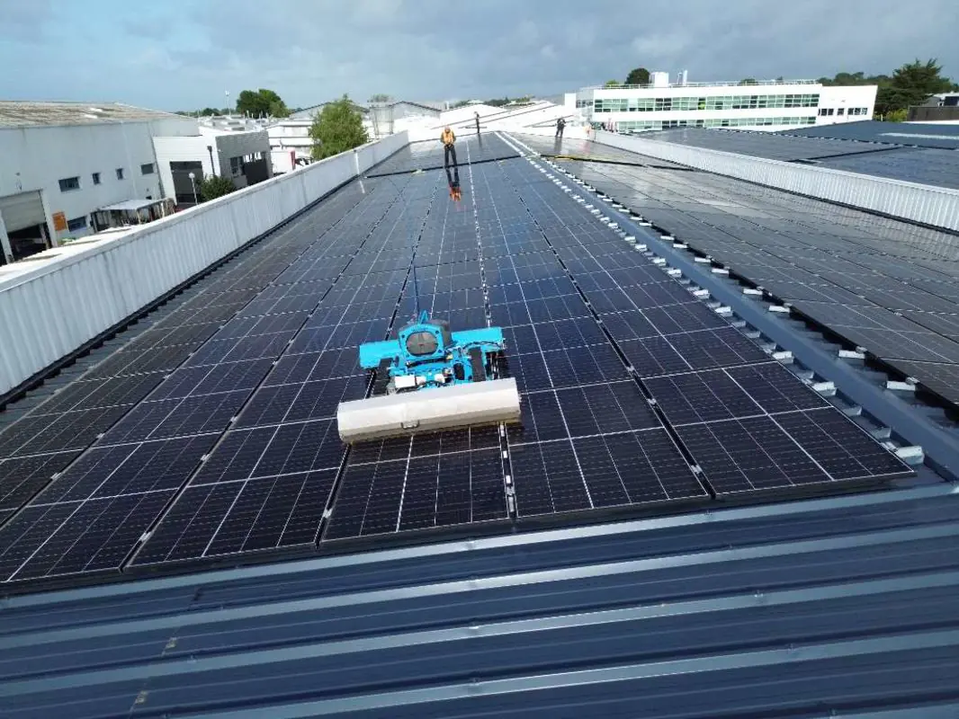 Nettoyage de panneaux solaires par un robot sur un toit d'usine