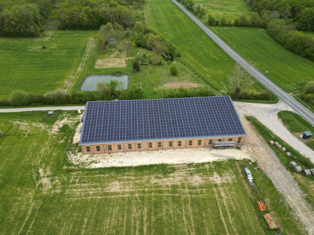 Bâtiment agricole GAEC Pachamama avec panneaux solaires dans un paysage rural