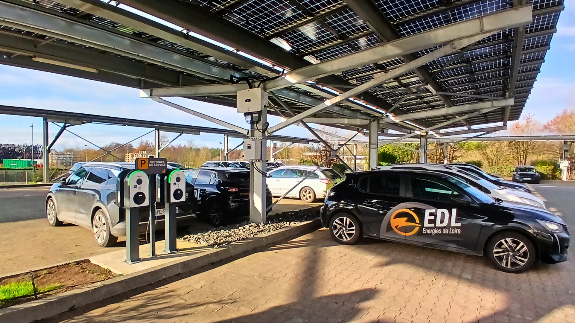 Voitures électriques se rechargeant sous des panneaux solaires, borne de recharge EDL