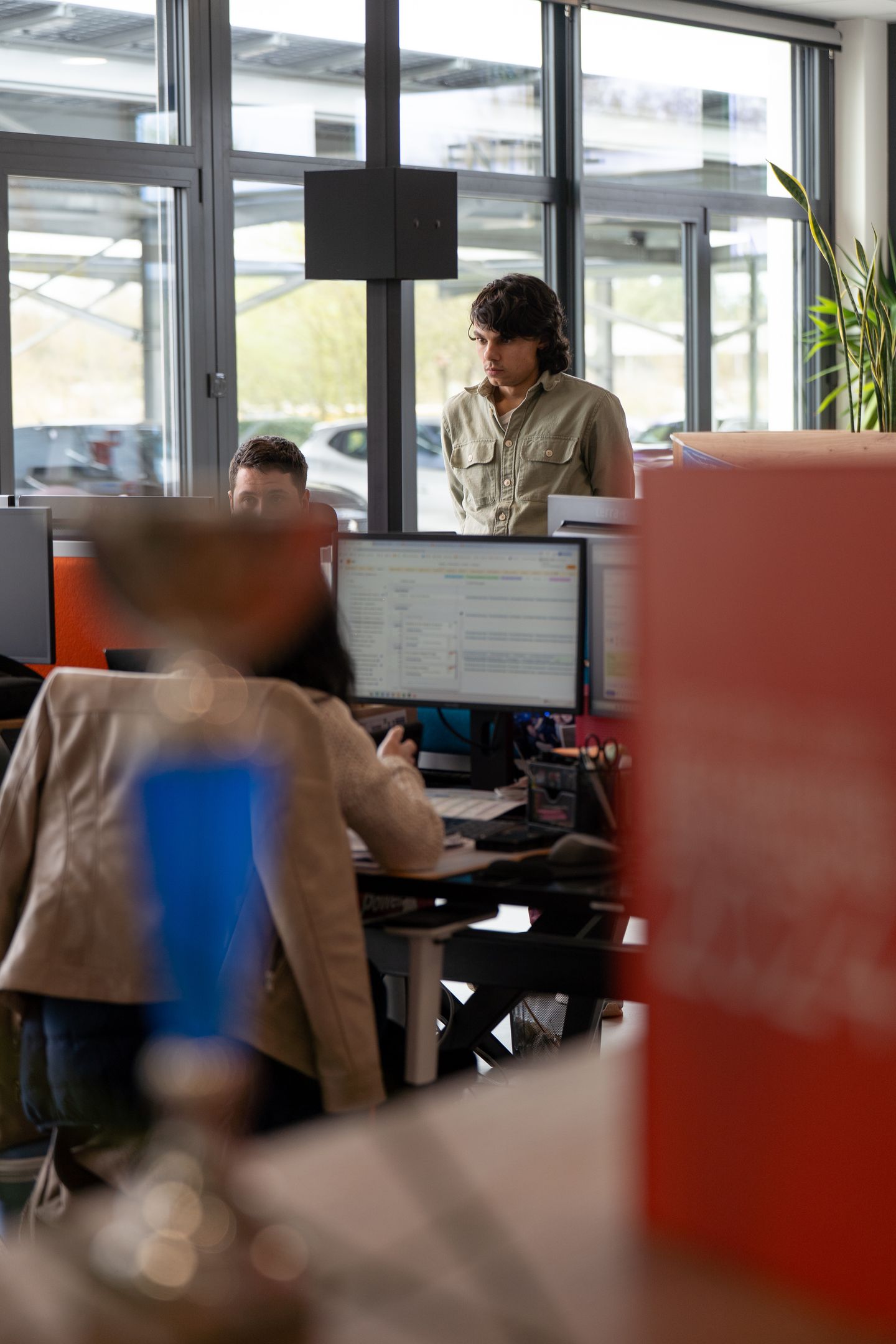 Homme en chemise déboutonné regardant un écran d'ordinateur dans un bureau moderne