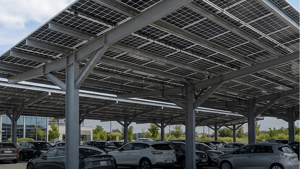 Ombrière solaire avec panneaux photovoltaïques au-dessus d'un parking de voitures.